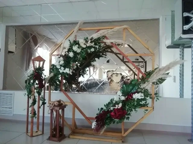 Деревянная геометрия, зелёные ветви и бело-бордовые цветы.