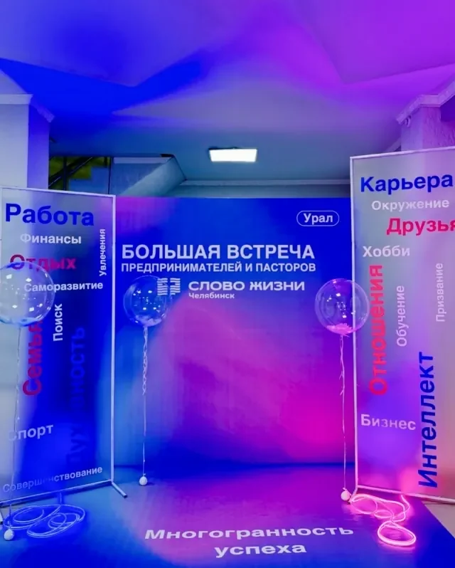 Брендированная фотозона с вертикальными текстовыми панелями и цветной подсветкой.